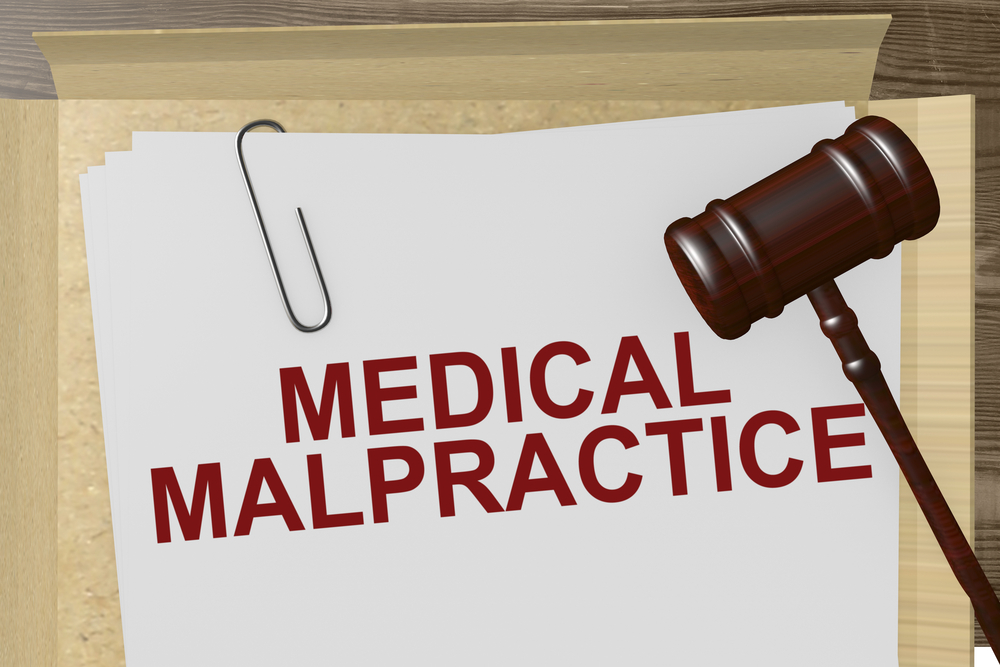 Judge's gavel with file folder labeled medical malpractice